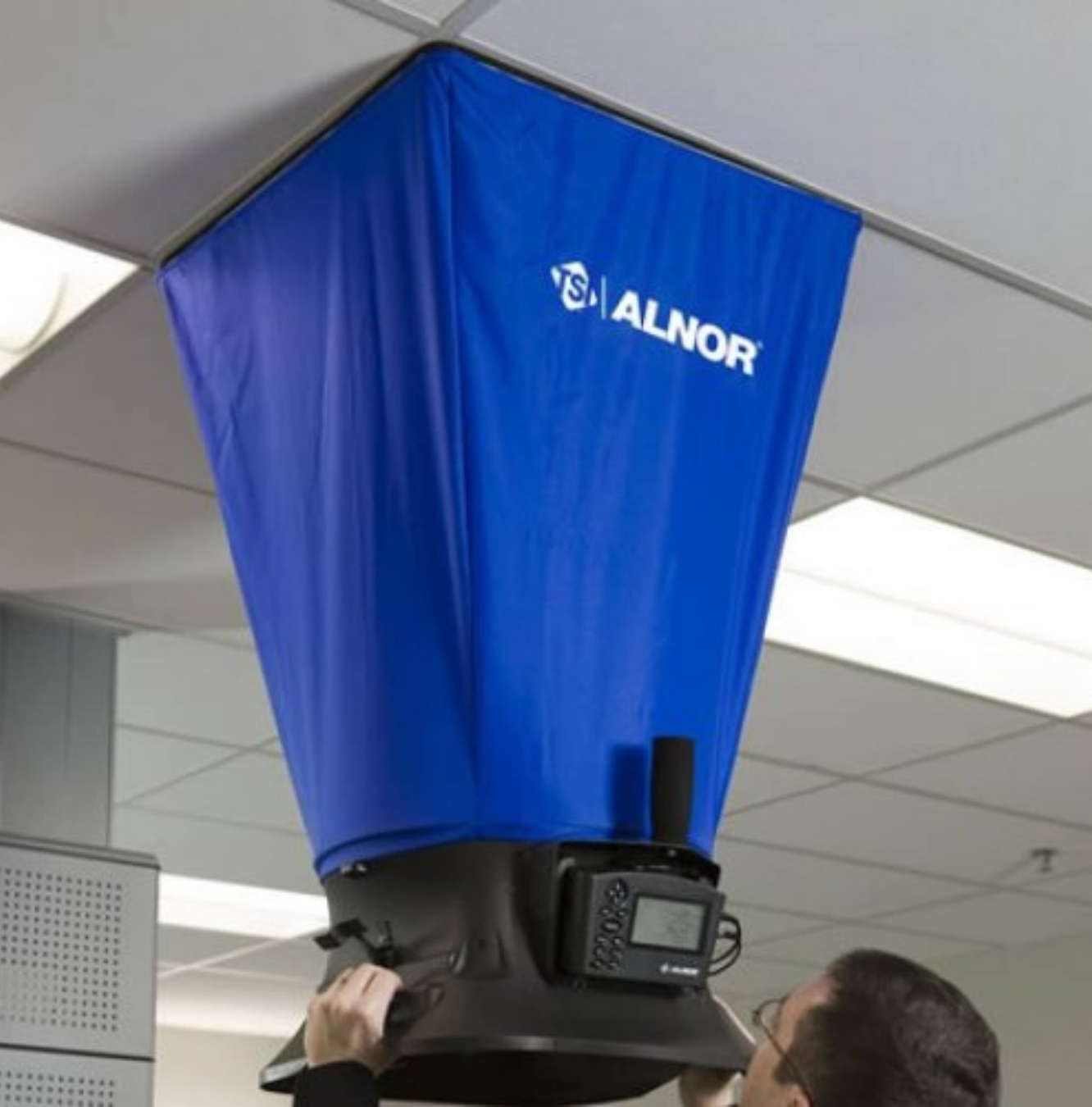 HVAC technician performing air balancing measurements